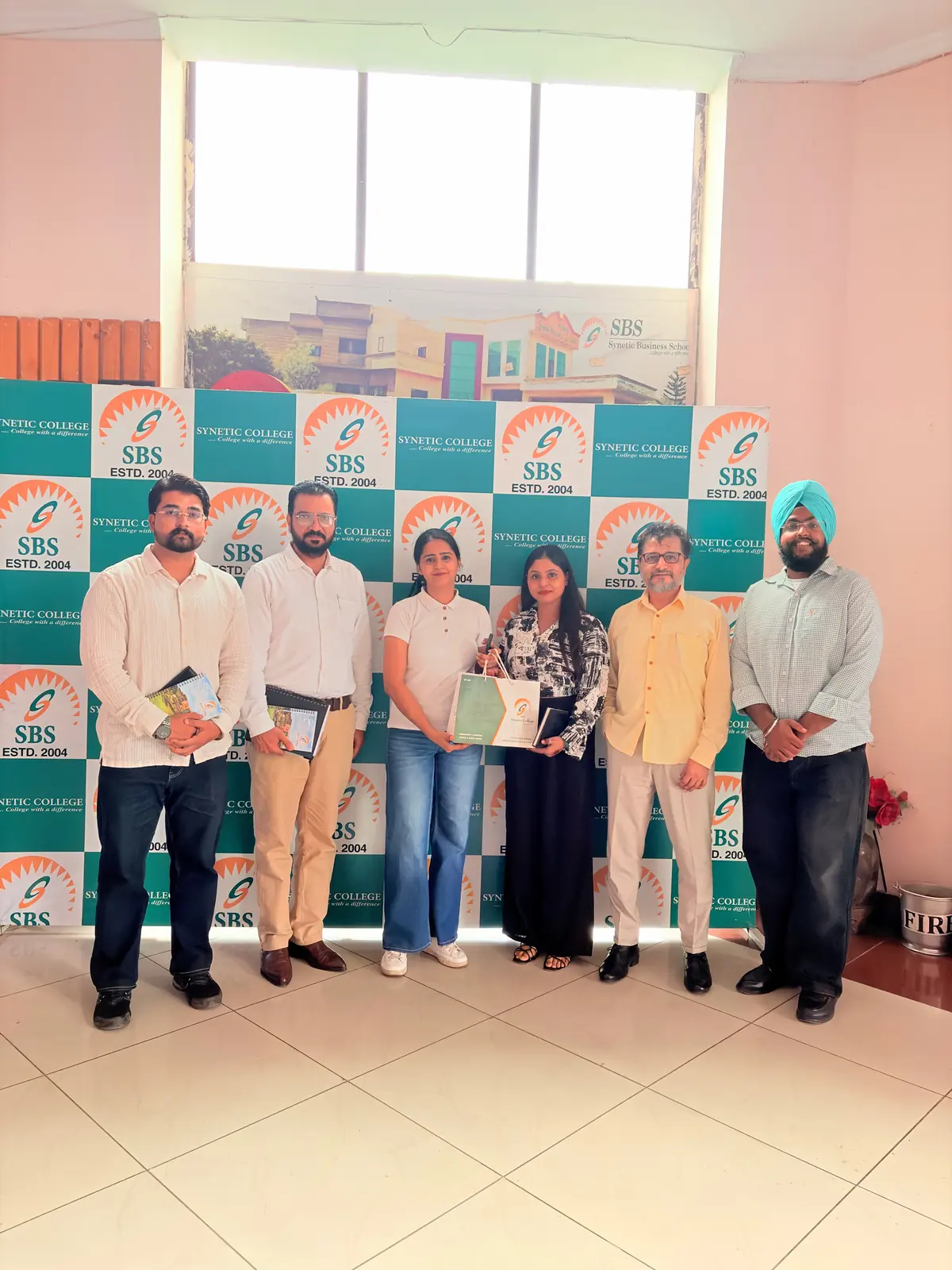 The Jwandsons team with SBS faculty at the campus placement drive, in front of the Synetic College backdrop