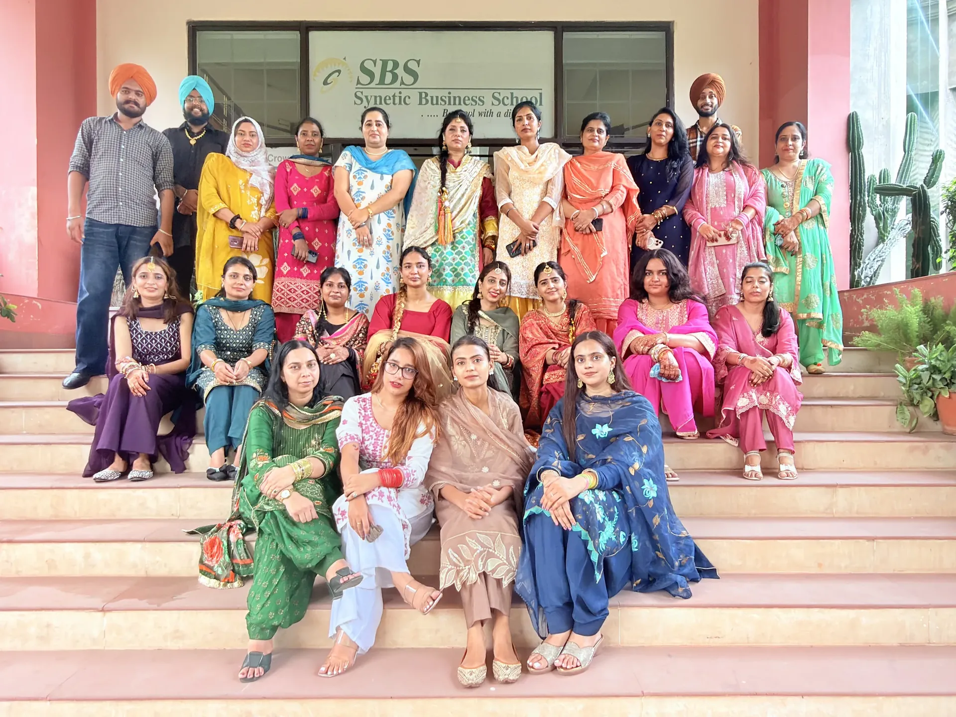 Staff and students in traditional Punjabi attire on the SBS steps for Teej